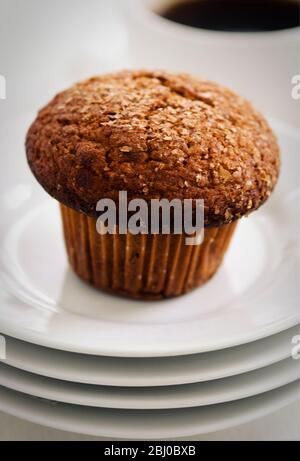 Zimtschnecken-Kleie Muffin auf weißen Tellern mit einer Tasse schwarzen Kaffee - Stockfoto