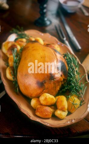 Lammkeule in gehackten Kräutern erstickt und in einer Teigkruste mit Bratkartoffeln serviert gewickelt. - Stockfoto