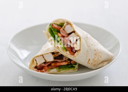 Sandwich Wrap mit Huhn, Speck, Tomaten und Salat - Stockfoto