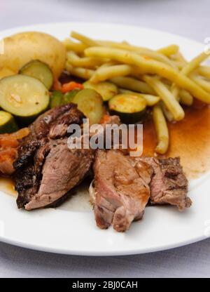 Mittagessen im Freien, von gegrilltem butterfliedertem Lammkeule, mit Ratatouille und gelben Wachsknospen - Stockfoto