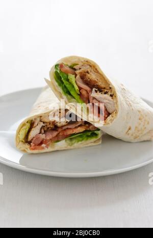 Sandwich Wrap mit Huhn, Speck, Tomaten und Salat - Stockfoto