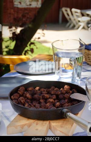 Bratpfanne mit schwedischen Fleischbällchen auf dem Tisch draußen in der Sommersonne - Stockfoto