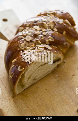 Stück süßes Hefebrot mit Mandeln und Mandelpaste auf Holzbrett - Stockfoto