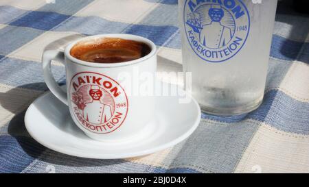 Kleine Tasse starken griechischen Kaffee, mit Glas Wasser auf dem Tisch des Strandrestaurants im Süden Zyperns - Stockfoto