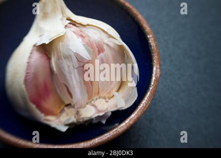 Einzelne Knoblauchzwiebel in einer kleinen Schüssel aufgebrochen - Stockfoto