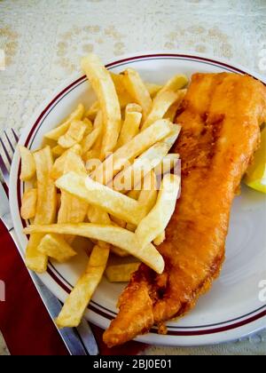 Klassischer britischer Fish and Chips auf dem Tisch in einem typischen Restaurant. - Stockfoto