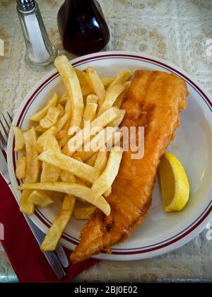 Klassischer britischer Fish and Chips auf dem Tisch in einem typischen Restaurant. - Stockfoto