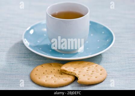 Zwei reichhaltige Teegebäck und eine Tasse grüner Tee als entspannende Pause - Stockfoto