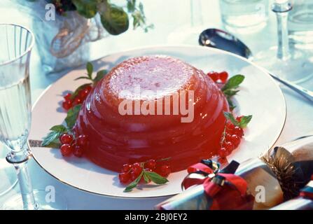 Alternative Weihnachts-Dessert - Gelee (Jello) von roten Beeren in geriffelte Schüssel gesetzt und mit roten Johannisbeeren verziert - Stockfoto