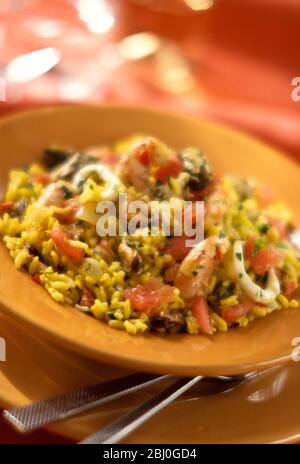 Gelbe Paella aus Safran auf Ockergelb. - Stockfoto