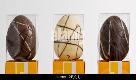 Drei ähnliche Schokolade Ostereier - einfach, Whie und Milchschokolade, Cellophan-Boxen. - Stockfoto