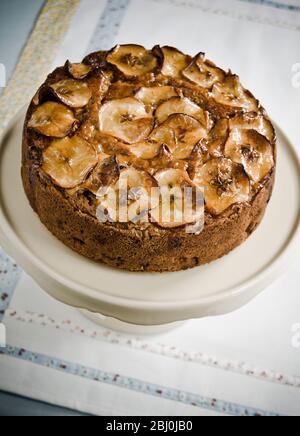 Apfelkuchen mit Apfelwein und Belag von glasierten Apfelscheiben - Stockfoto