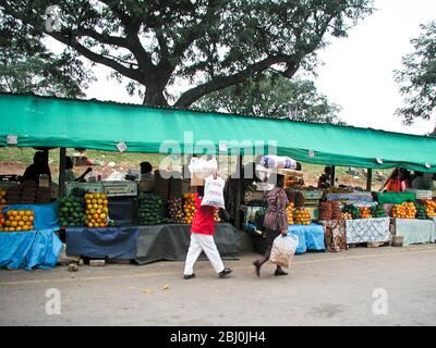 Obst- und Gemüsemarkt in Nelspruit - Mpumalanga, Südafrika, mit Menschen, die Waren auf dem Kopf tragen - Stockfoto