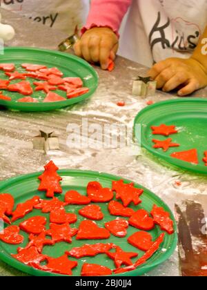 Kinder schneiden dekorative Weihnachtsformen aus farbigen Fondant Vereisung Kuchen dekorieren - Stockfoto