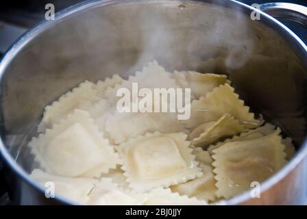 Ravioli in kochendem Wasser in Edelstahlpfanne gekocht Stockfoto