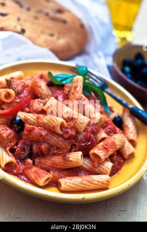 Rigatoni Pasta Formen, Tomatentunfisch und schwarze Olivensauce - Stockfoto