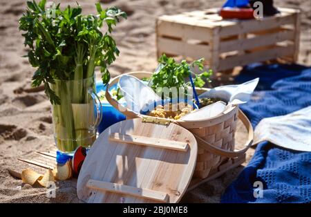 Strandpicknick mit Salaten in Schalen und Körben - Stockfoto