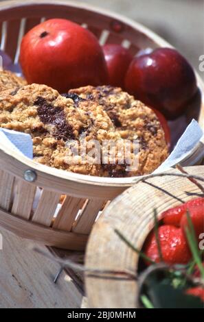 Choc Chip Cookies und leuchtend rote Äpfel im Korb als Teil des Strand-Picknick - Stockfoto