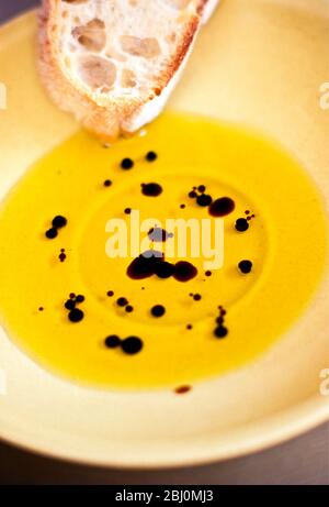 Olivenöl mit Balsamico-Essig in gelber Töpferschale mit Ciabatta-Brot - Stockfoto