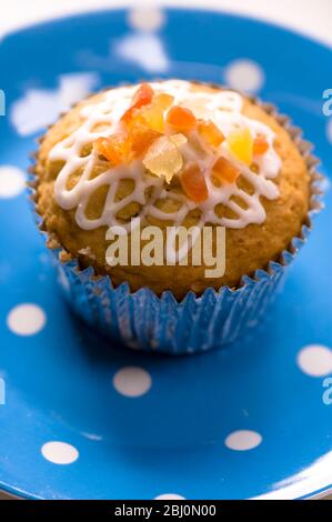 Muffin mit Squiggly Eisbildung und kandierten Schale auf gepunkteten blauen Teller verziert - Stockfoto