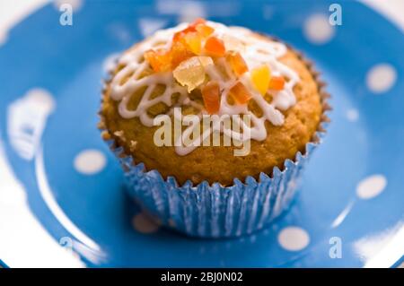 Muffin mit Squiggly Eisbildung und kandierten Schale auf gepunkteten blauen Teller verziert - Stockfoto