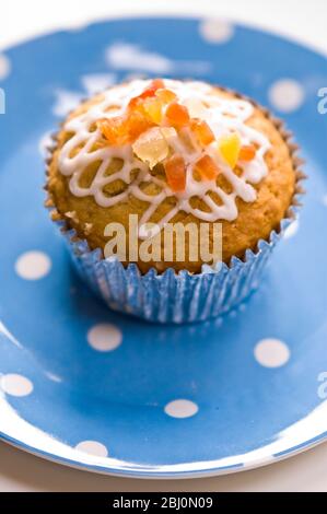 Muffin mit Squiggly Eisbildung und kandierten Schale auf gepunkteten blauen Teller verziert - Stockfoto