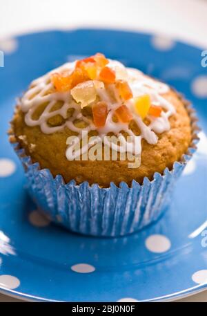 Muffin mit Squiggly Eisbildung und kandierten Schale auf gepunkteten blauen Teller verziert - Stockfoto