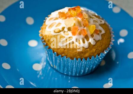 Muffin mit Squiggly Eisbildung und kandierten Schale auf gepunkteten blauen Teller verziert - Stockfoto