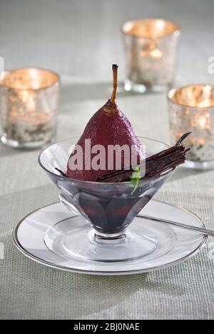Birnen pochiert in Rotwein mit Teelichter in Party-Setting - Stockfoto