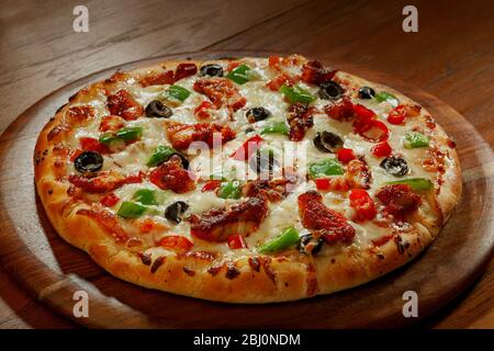 Leckere kitschige Pizza auf einem Holzteller. Stockfoto