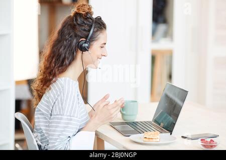 Horizontale Seitenansicht Aufnahme von jungen kaukasischen Frau zu Hause während der Quarantäne arbeiten Stockfoto