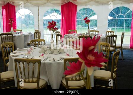 Interieur von Festzelt für eine Sommerhochzeit in den Farben rosa und weiß dekoriert - Stockfoto