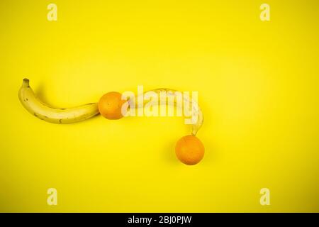 Obstbanane und Orange auf gelbem Hintergrund Stockfoto