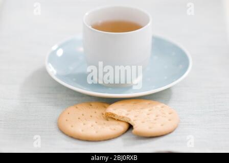 Zwei reichhaltige Teegebäck und eine Tasse grüner Tee als entspannende Pause - Stockfoto