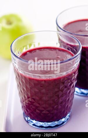 Gesunder Snack aus frisch gemachter Johannisbeere und Himbeer-Smoothie mit frischem grünen Apfel - Stockfoto