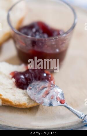 Zerbrochenes knuspriges Brot mit Klecks von kernloser Himbeermarmelade - Stockfoto