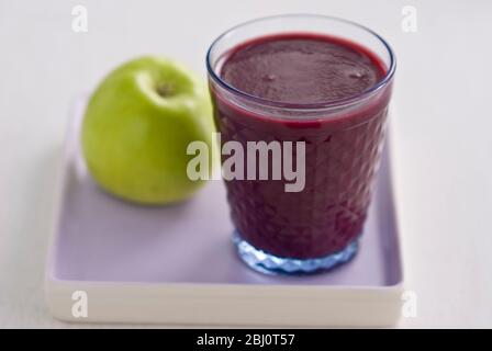 Gesunder Snack aus frisch gemachter Johannisbeere und Himbeer-Smoothie mit frischem grünen Apfel - Stockfoto