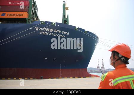 Qingdao, Qingdao, China. April 2020. ShangdongÃ¯Â¼Å'CHINA-am 26. April machte die HMM algesilas, der weltweit größte Containerschiff mit einer Containerladung von 24,000 TEU, ihre Jungfernfahrt zum Hafen Qingdao in der provinz shandong. Das Schiff, das am Montag in Südkorea ausgeliefert wurde, ist 399.9 Meter lang, 61.03 Meter breit und 33.2 Meter tief und damit das größte Containerschiff der Welt in Betrieb. Quelle: SIPA Asia/ZUMA Wire/Alamy Live News Stockfoto