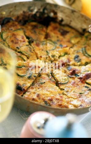 Frittata mit Zucchini und Speck in der Pfanne serviert - Stockfoto