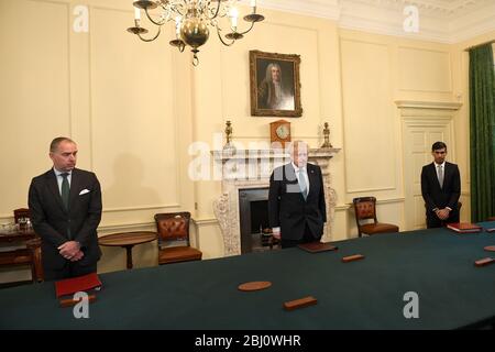 (Von links nach rechts ) Kabinettsminister Mark Sedwill, Premierminister Boris Johnson und Schatzkanzler Rishi Sunak stehen in der Downing Street 10, London, um ein Schweigeminute zu beobachten, in dem die Mitarbeiter des NHS und die Schlüsselarbeiter, die während des Coronavirus-Ausbruchs gestorben sind, zu Ehren sind. Stockfoto