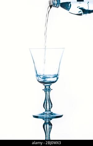 Wasser aus einer Plastikflasche in ein Glas gegossen Stockfoto