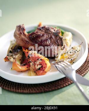 Gegrilltes Lammkotelett auf gebratenem Gemüse, auf weißem Teller, mit gebratenem Squash Fenchel und Sesamsamen - Stockfoto