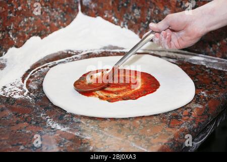 Pizza auf Marmortisch vorbereiten, Nahaufnahme Stockfoto