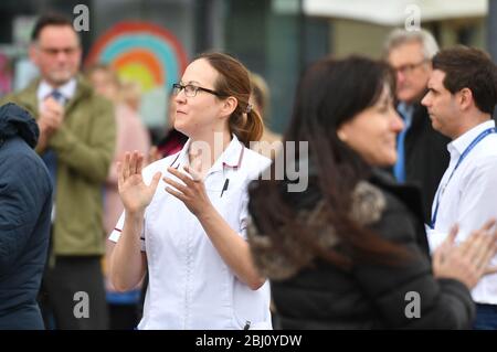 Die Mitarbeiter stehen vor dem Royal Derby Hospital, während einer Schweigeminute, um dem NHS-Personal und den Schlüsselarbeitern, die während des Coronavirus-Ausbruchs gestorben sind, Tribut zu zollen. Stockfoto