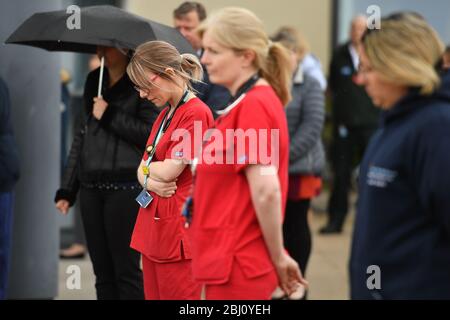 Die Mitarbeiter stehen vor dem Royal Derby Hospital, während einer Schweigeminute, um dem NHS-Personal und den Schlüsselarbeitern, die während des Coronavirus-Ausbruchs gestorben sind, Tribut zu zollen. Stockfoto