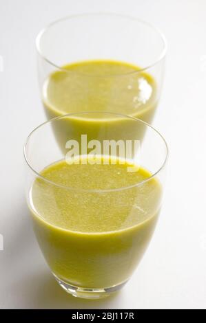 Frisch gesaftet Kiwi Obst und Orange in zwei Gläsern auf weißem Hintergrund - Stockfoto