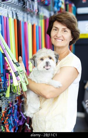 Erwachsene Frau besucht Tierhandlung auf der Suche nach Zubehör für ihren Hund Stockfoto