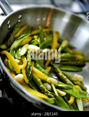 Pfanne mit frischem Gemüse, das unter Rühren gebraten wird - Stockfoto