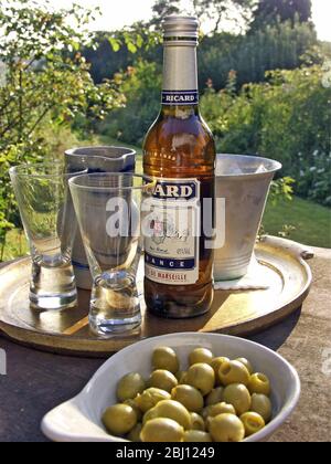 Zwei Gläser pernod-Getränk, das in der Abendsonne gegossen wird - Stockfoto