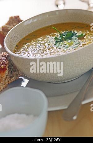 Schüssel mit Karotten- und Koriandersuppe mit knusprigem Brot - Stockfoto